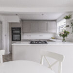 Bright kitchen with Bluetta Carrara Quartz island worktop and a hob set into the smooth white surface