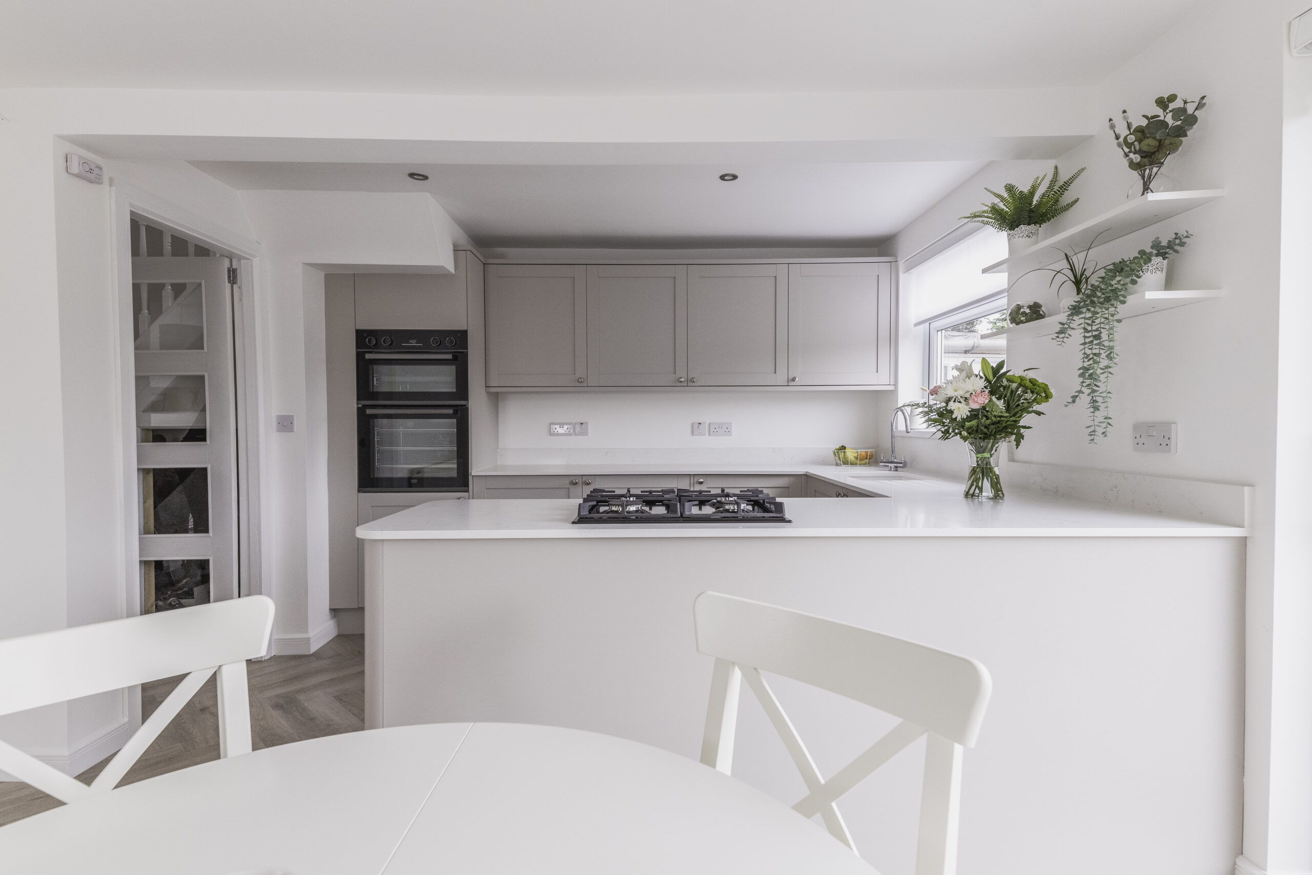 Bright kitchen with Bluetta Carrara Quartz island worktop and a hob set into the smooth white surface