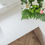 Bluetta Carrara Quartz worktop corner close-up showing a smooth edge and clean white finish near flowers