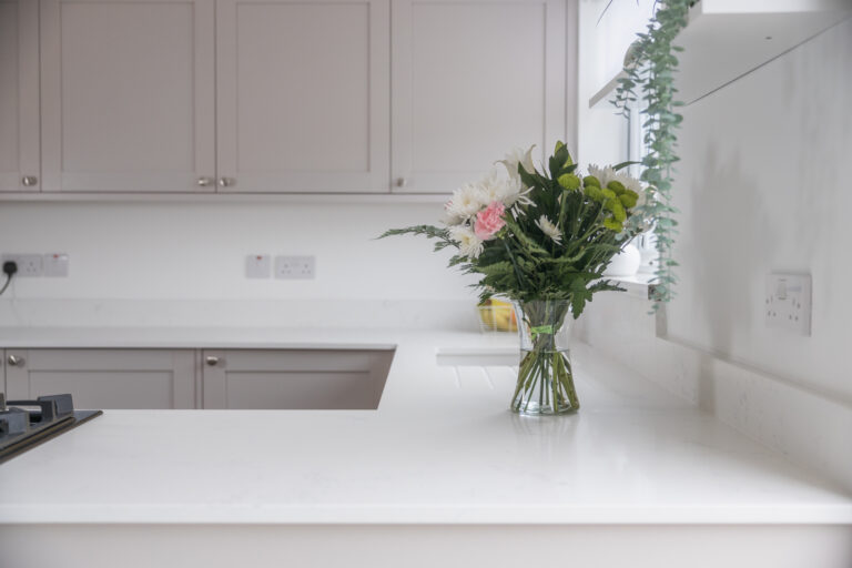 Bluetta Carrara Quartz worktop run with an undermount sink and a smooth bright white surface finish