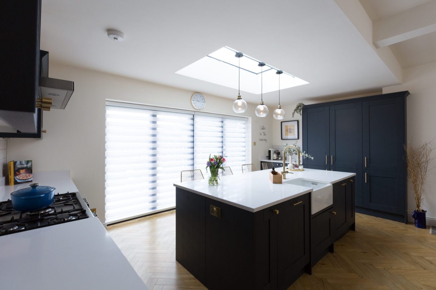 Blanco Zeus Quartz island worktop in an open-plan kitchen with bright white surface and pendant lights above