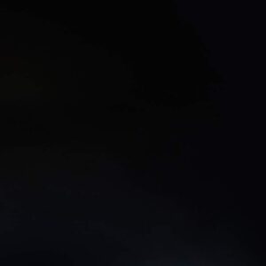 Magma Black Porcelain worktop sample display with a sunflower bouquet on the corner above a wood-effect surface