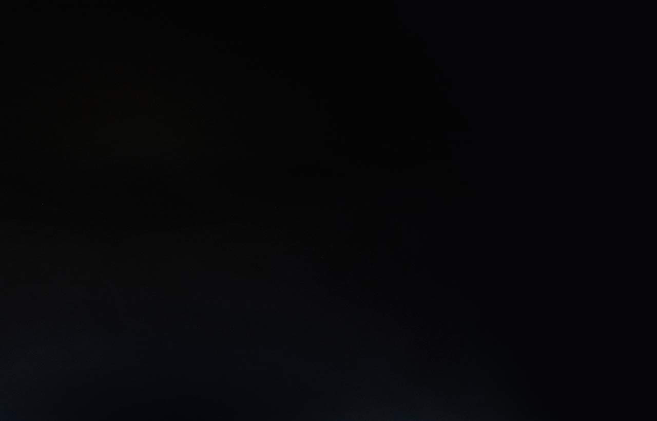 Magma Black Porcelain worktop sample display with a sunflower bouquet on the corner above a wood-effect surface