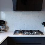 Grey Drift Quartz worktop behind a gas hob showing pale grey stone-effect movement and clean cut-out lines