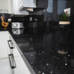 Black Starlight Quartz worktop close-up along a kitchen run showing reflective flecks across the black surface