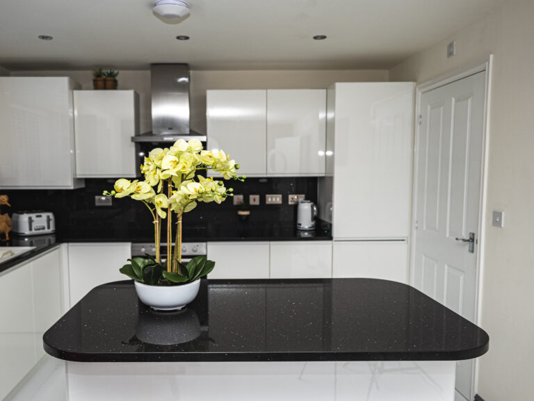 Modern kitchen with a Black Starlight Quartz island worktop showing a deep black surface with subtle sparkle