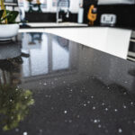 Black Starlight Quartz worktop surface close-up showing sparkle flecks and reflections across the polished black finish