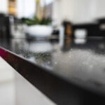Macro close-up of Black Starlight Quartz worktop showing fine reflective speckles on a polished black surface