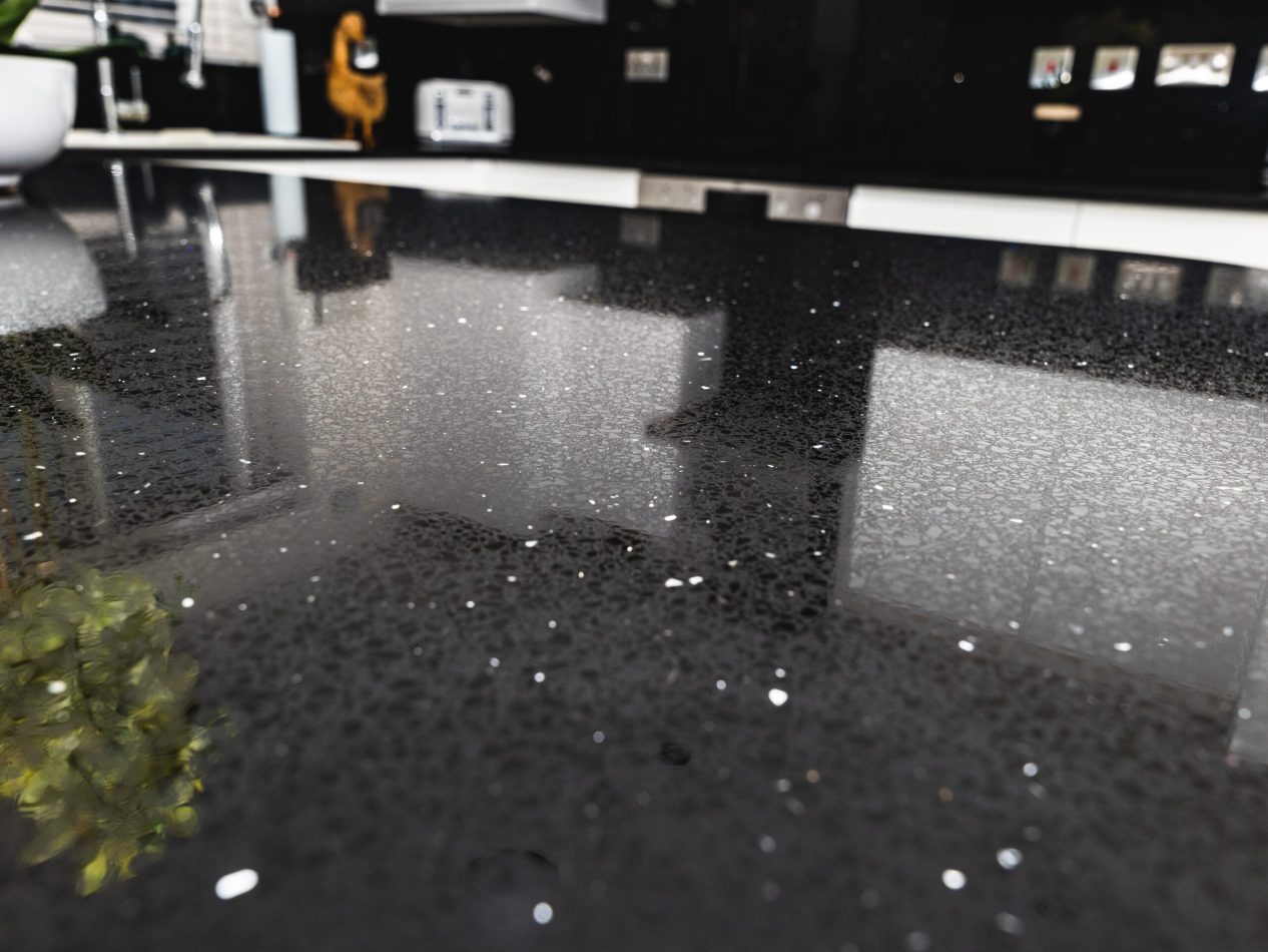 Close-up of Black Starlight Quartz worktop showing reflective sparkle flecks across a polished black surface