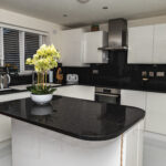 Wide kitchen view featuring a Black Starlight Quartz island with a curved end and subtle sparkle finish