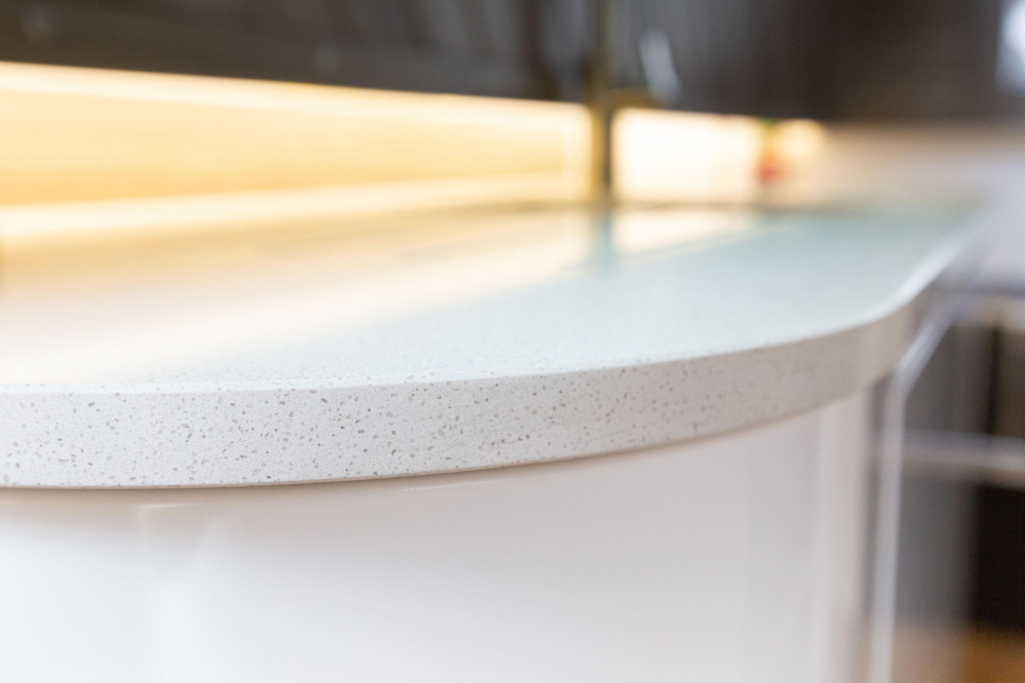 Ice White Quartz worktop edge close-up showing a rounded front profile and smooth white finish