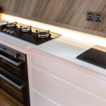 Ice White Quartz worktop in a narrow boat galley with a gas hob and sink set into the surface