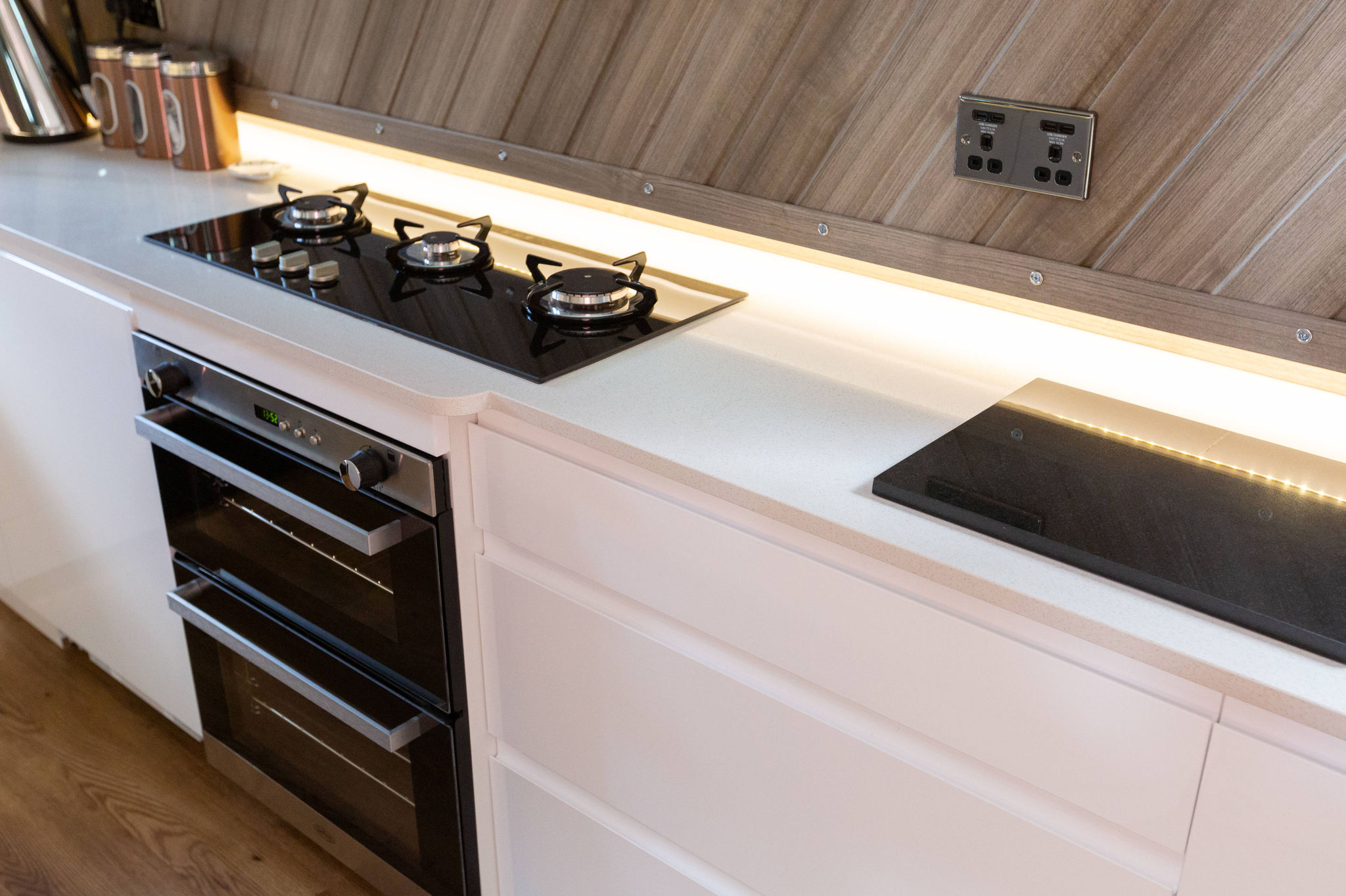 Ice White Quartz worktop in a narrow boat galley with a gas hob and sink set into the surface
