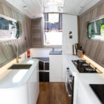 Long view down a narrow boat kitchen with Ice White Quartz worktops running along both sides