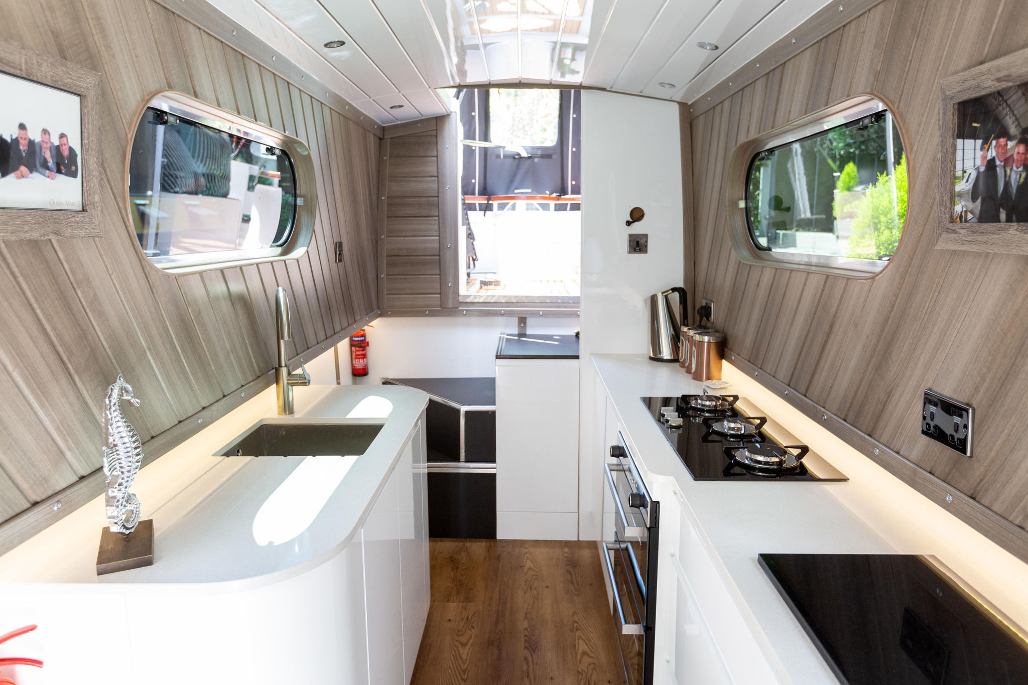Long view down a narrow boat kitchen with Ice White Quartz worktops running along both sides