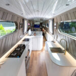 Full narrow boat kitchen overview with Ice White Quartz worktops, hob run and sink run visible along the galley