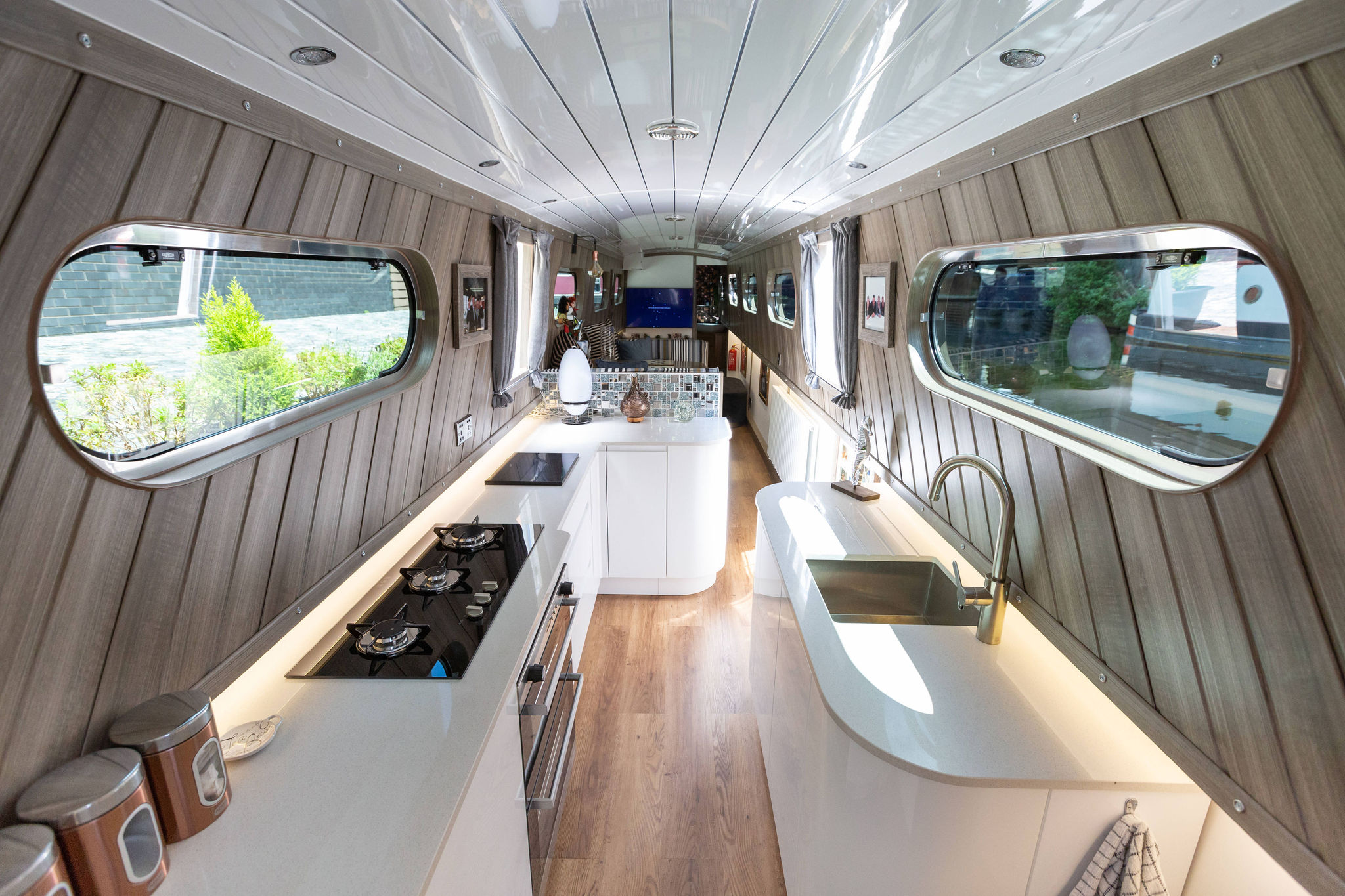 Full narrow boat kitchen overview with Ice White Quartz worktops, hob run and sink run visible along the galley