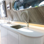 Sink and tap area in a narrow boat kitchen with Ice White Quartz worktop and curved end section