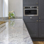Depth of field shot of Ivory Fantasy Granite worktop surface leading to the sink area, showing the Granite pattern and smooth polished finish.