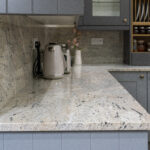 Ivory Fantasy Granite worktop and matching backsplash in a modern kitchen with grey cabinetry