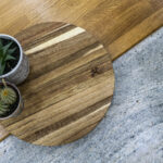 Close up of Ivory Fantasy Granite worktop surface with a wooden serving board and plants, highlighting the Granite pattern and polished finish.
