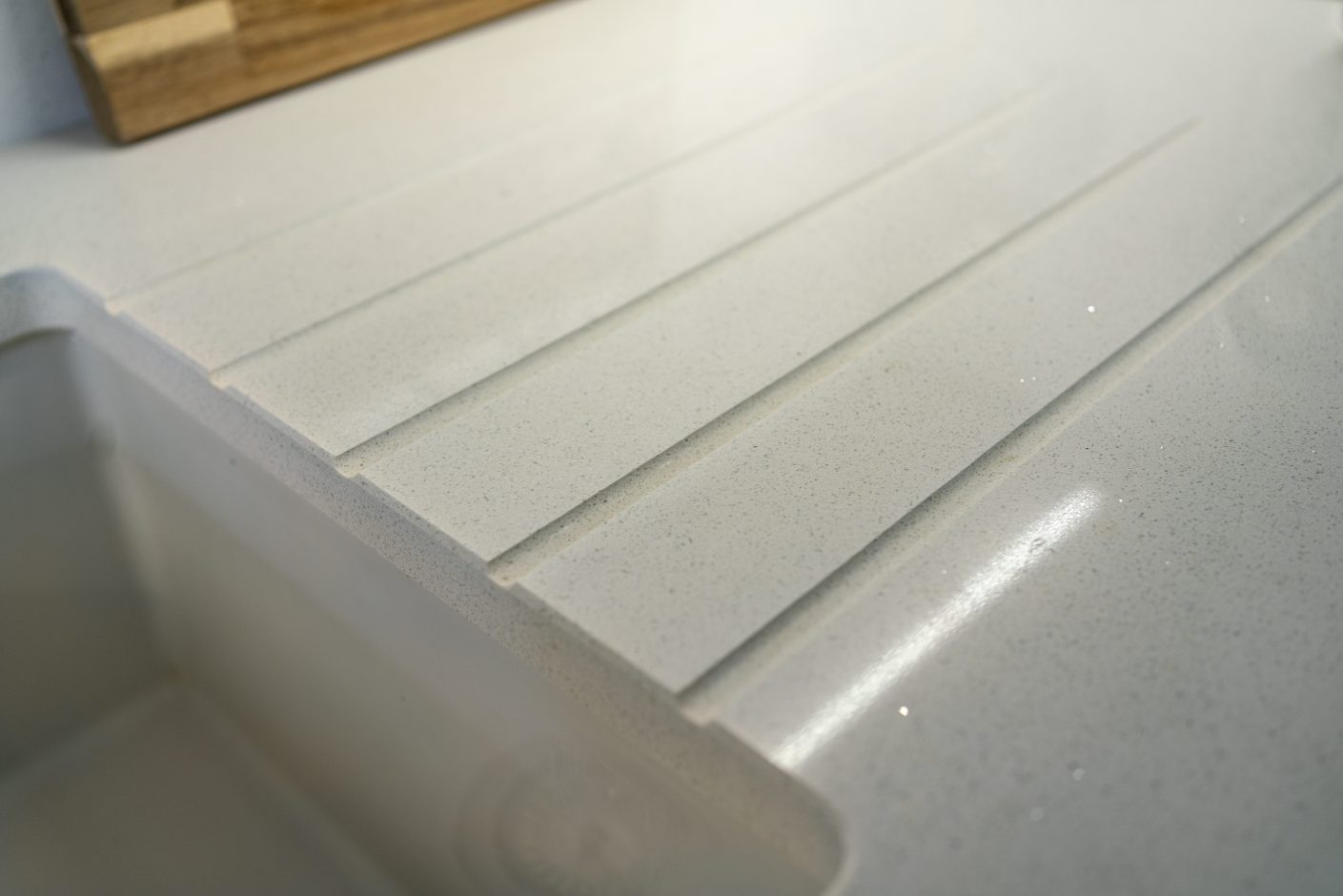 Close up of Aspen Shimmer Quartz drainer grooves with polished finish