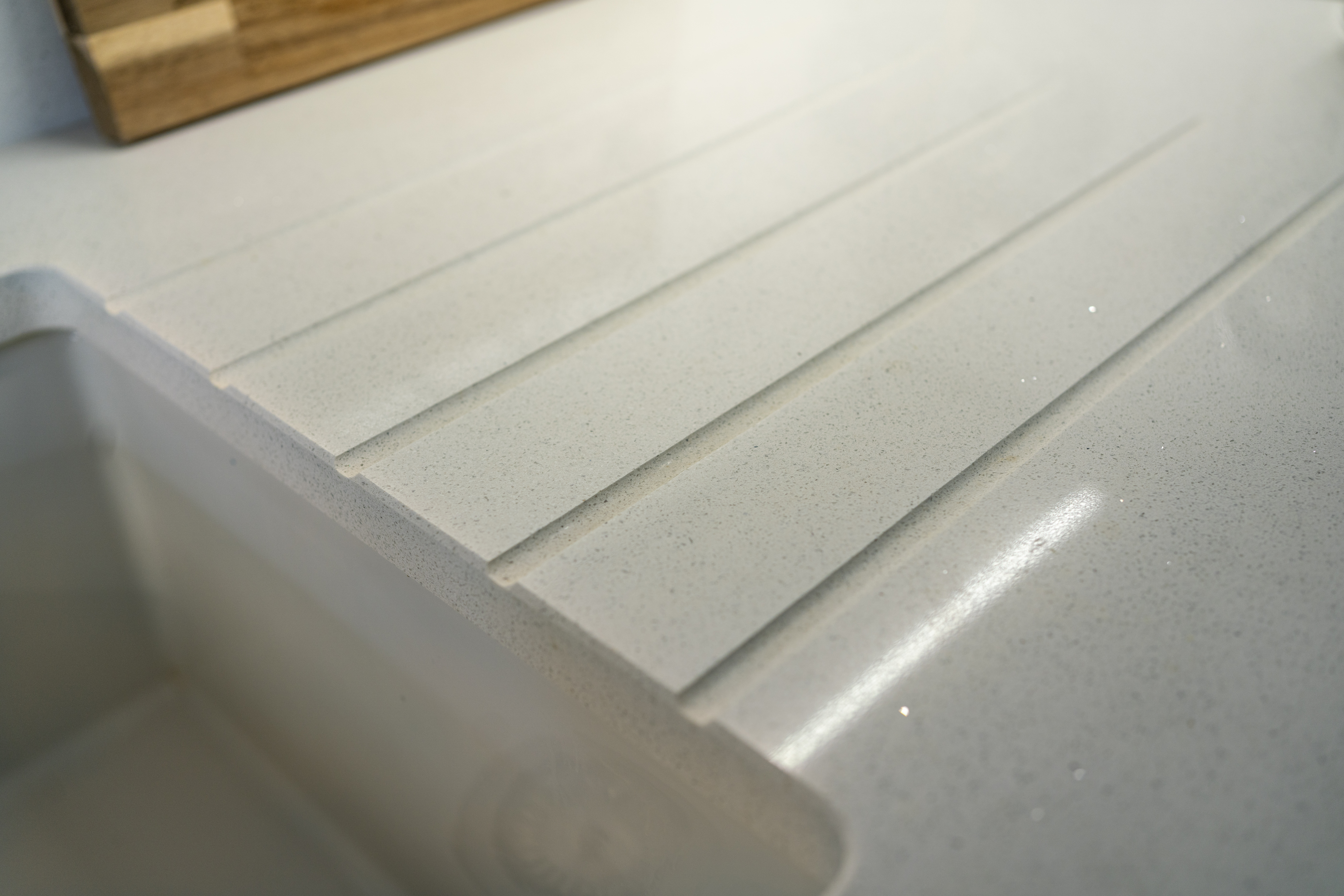 Close up of Aspen Shimmer Quartz drainer grooves with polished finish