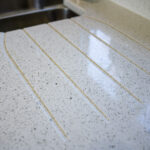 White Starlight Quartz worktops with precision cut drainer grooves near the sink