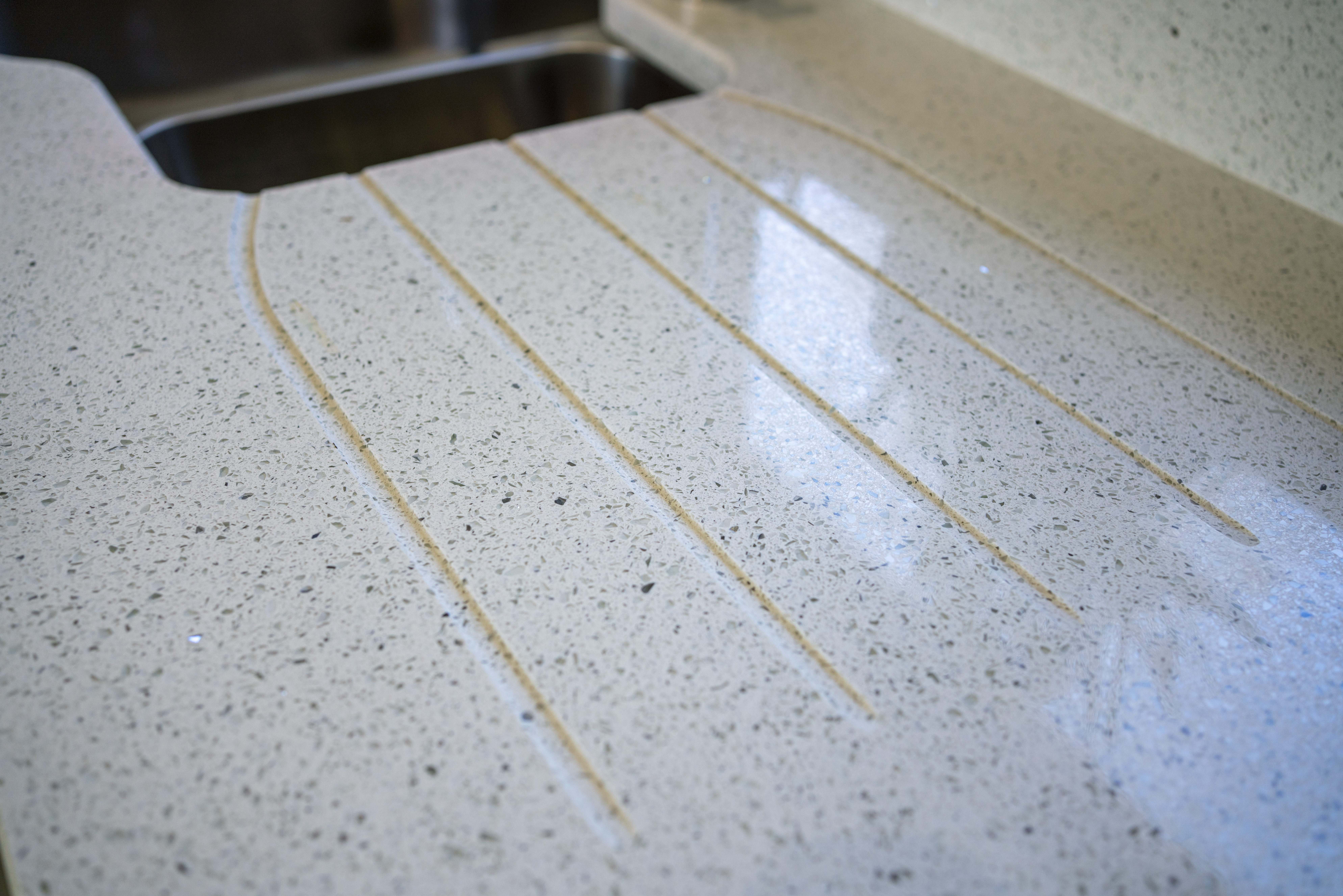 White Starlight Quartz worktops with precision cut drainer grooves near the sink