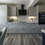 Modern kitchen fitted with White Starlight Quartz worktops and light grey cabinetry