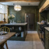 Gold Calacatta worktops in a traditional kitchen with green cabinetry and chandelier lighting
