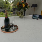 Drinks setup on Carrara Quartz worktop with bottle and glasses