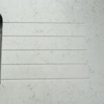 Carrara Quartz worktop with drainer grooves above a stainless steel sink