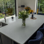 Carrara Quartz worktop beside large window with flower vase