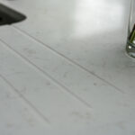 Drainer grooves cut into Carrara Quartz worktop beside stainless steel sink