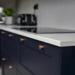 Carrara Quartz island with navy chairs in a modern open kitchen