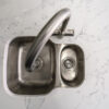 Close up of chrome tap fitted into White Calacatta Quartz worktop with grey veining