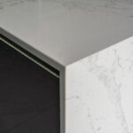 White Calacatta Quartz waterfall island corner showing polished edge and grey veining