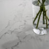 Close up of White Calacatta Quartz worktop surface with grey veining and vase of flowers