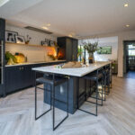 Wide view of a modern kitchen featuring an Olympus White Quartz island with subtle grey veining