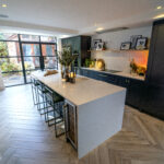 Modern kitchen view showing an Olympus White Quartz island worktop with seating and gentle veining