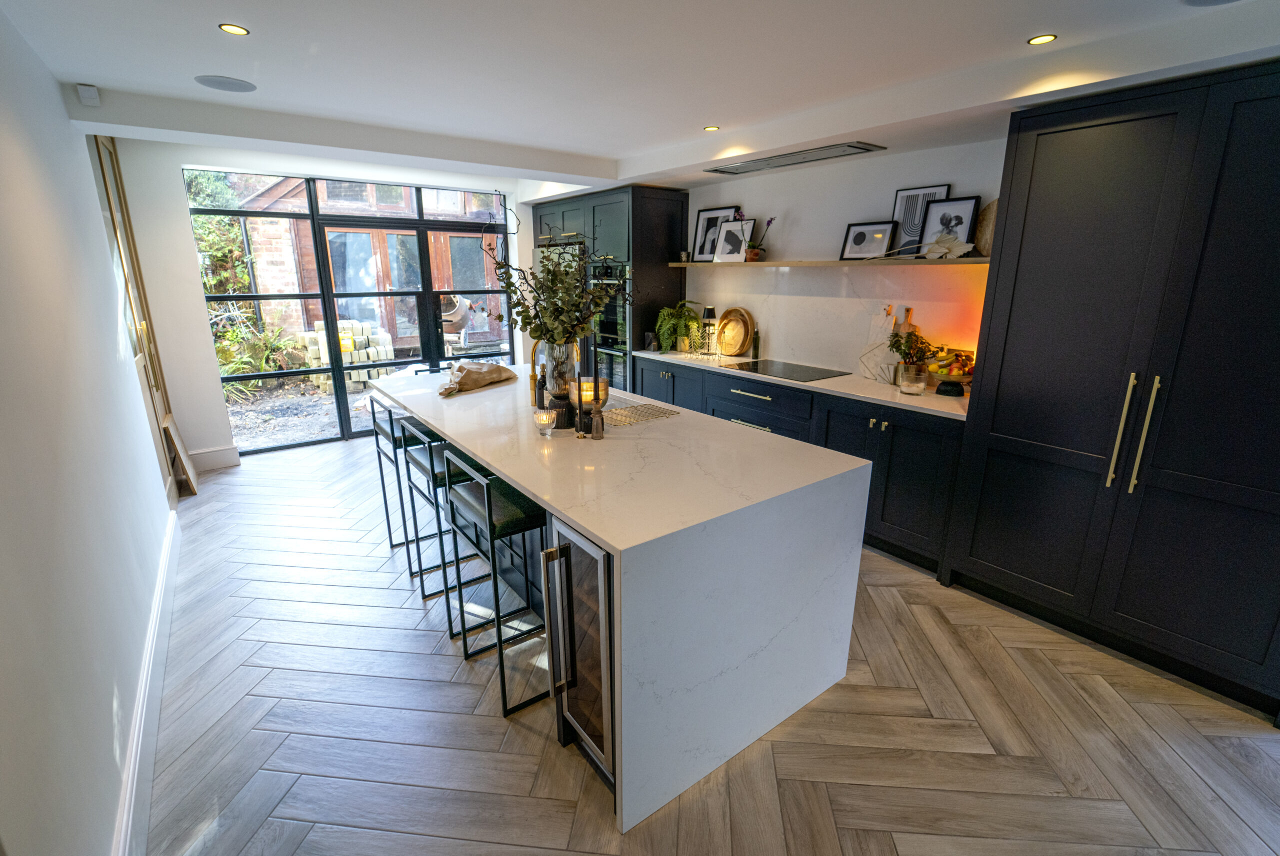 Modern kitchen view showing an Olympus White Quartz island worktop with seating and gentle veining