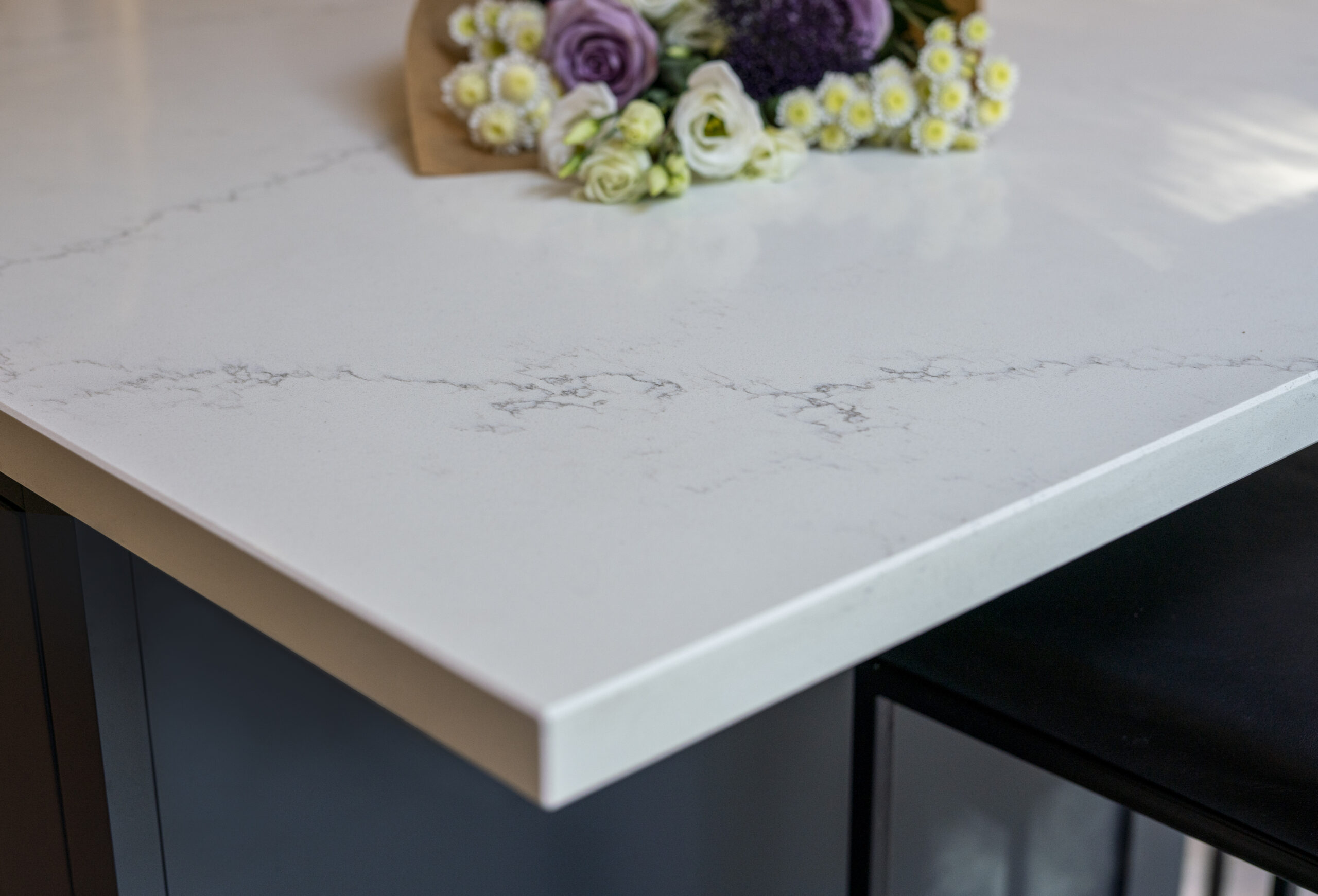 Olympus White Quartz worktop corner close-up with soft grey veining across a bright white finish