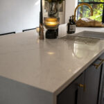 Close-up of Olympus White Quartz worktop edge with subtle grey veining and a polished finish
