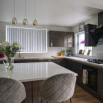 Wide view of a modern kitchen with Imperial White Quartz worktops on the perimeter and island