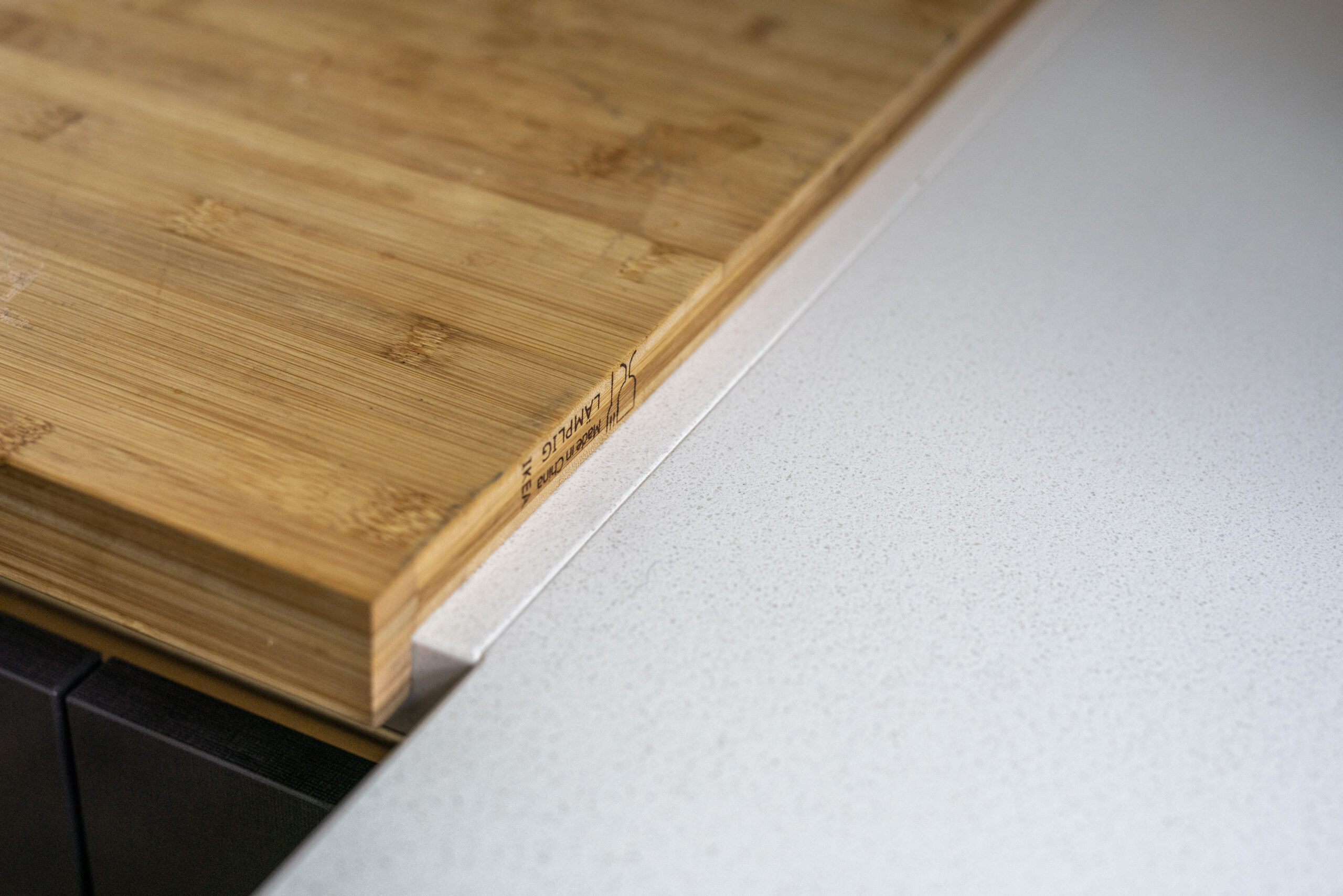 Imperial White Quartz worktop close-up with a wooden chopping board resting on the smooth white surface