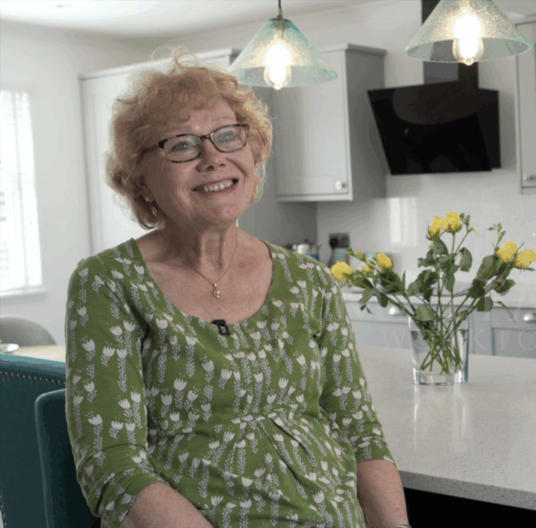 Customer giving a testimonial in her kitchen featuring White Starlight Quartz worktops from Mayfair Worktops
