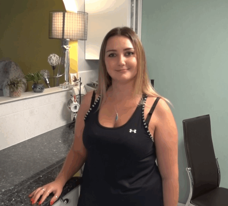 Testimonial video still of a customer standing in their kitchen after a Blue Pearl Granite worktop installation by Mayfair Worktops.