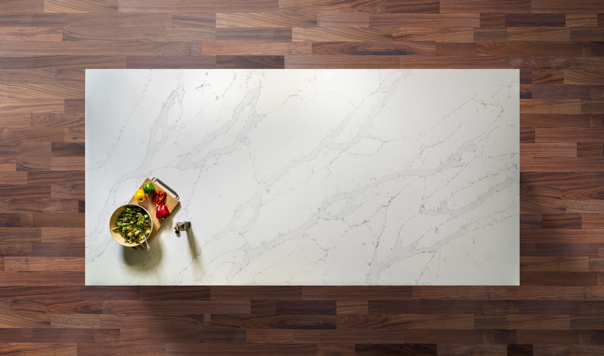 White Calacatta Quartz slab displayed on a wooden surface with food styling and grey veining