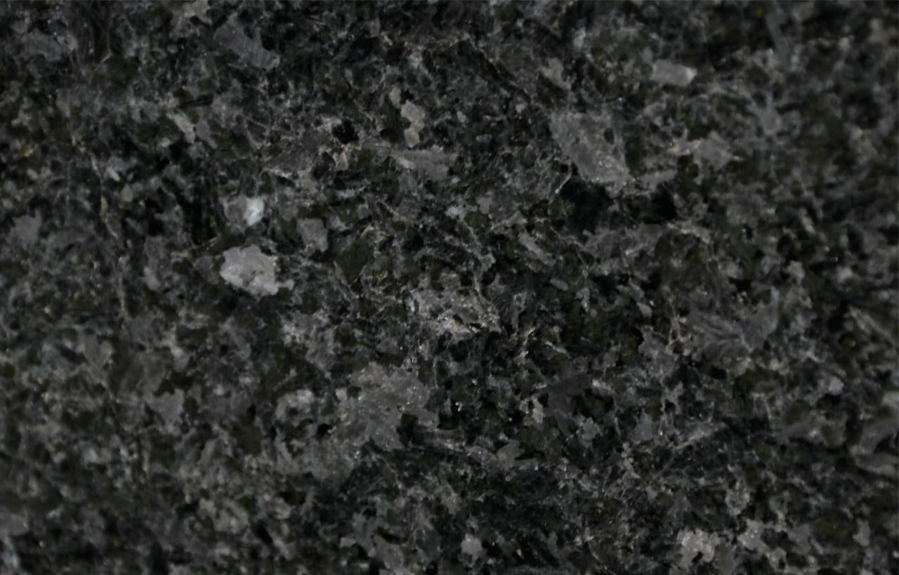 Close up slab photo of Angola Black Granite showing a dense dark crystal pattern with natural grey and black movement across the surface.